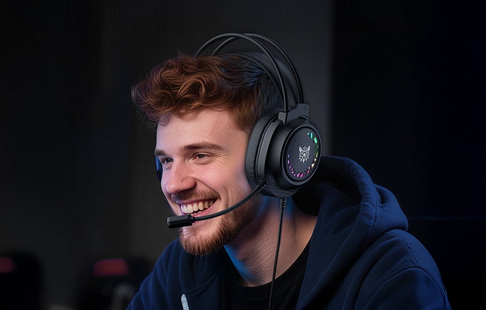 Smiling boy with headphones on his head in a dark room