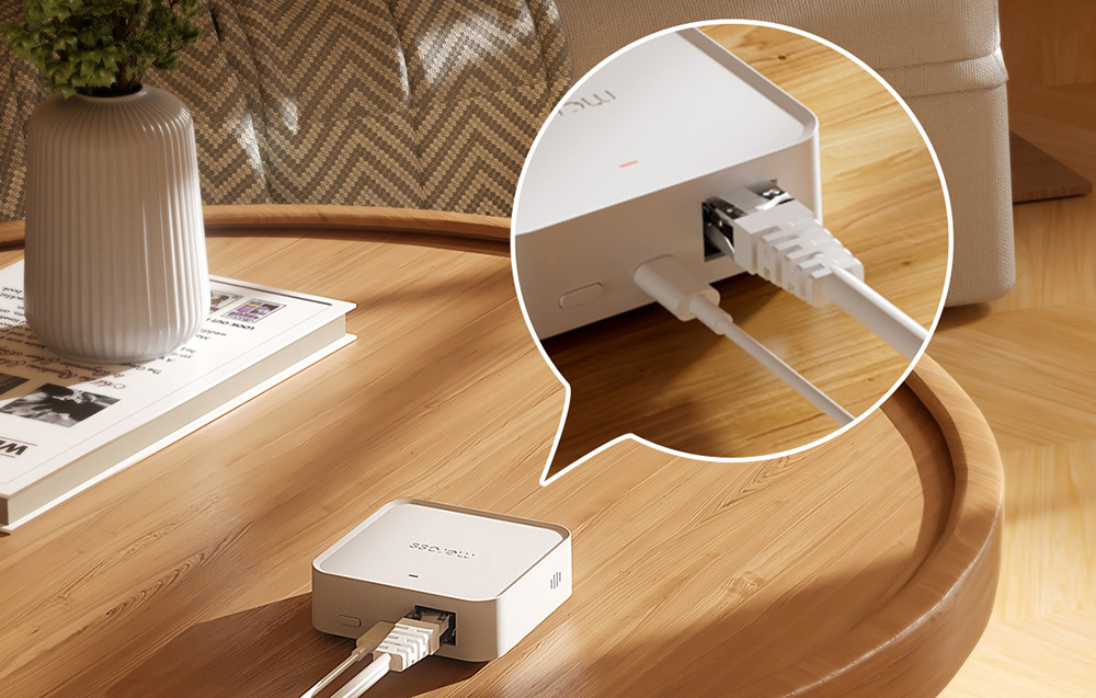 Meross smart hub on a table with Ethernet and power cables connected, zooming in on the ports