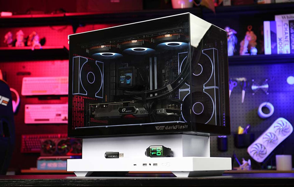 Computer case with transparent panels and white stand on a workshop background with colored lighting