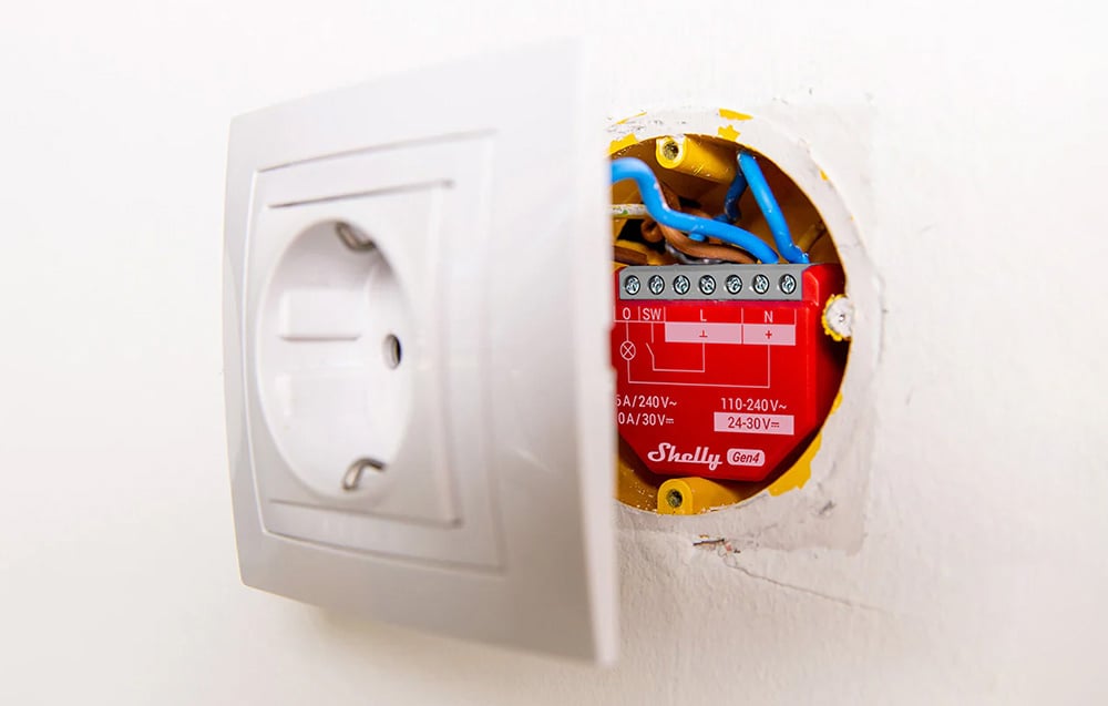 Controller placed in the wall behind an electrical outlet, showing the flush-mount installation method.