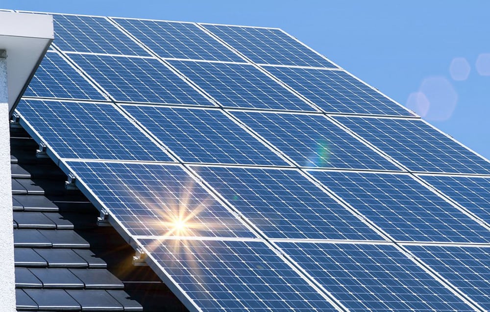 Close-up of solar panels on a roof, reflecting the sun’s rays