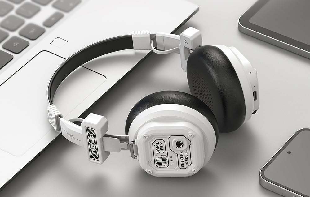 White Onikuma headphones lying on a laptop, next to a tablet with a smartphone