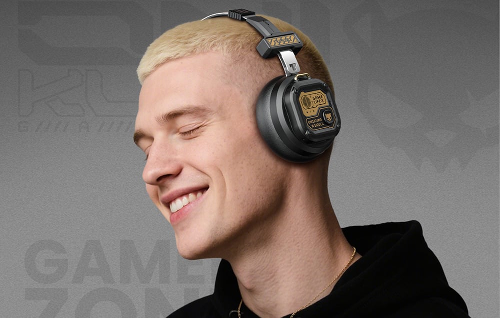 A smiling man with light hair listening to music through Onikuma headphones