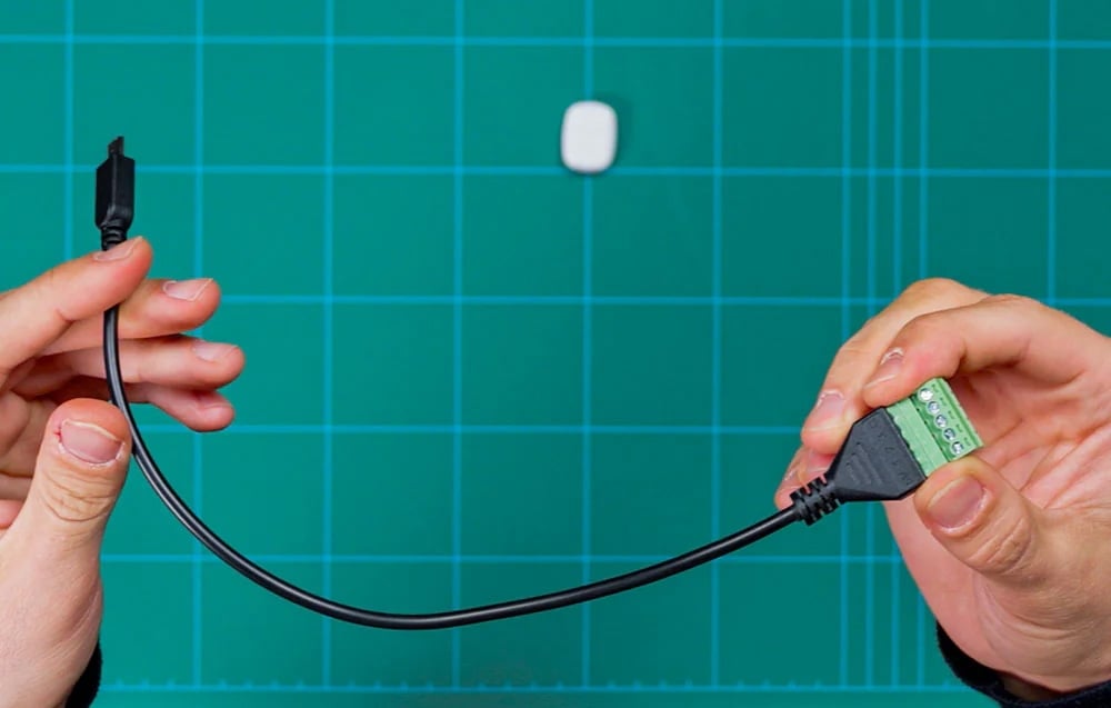 5-pin Shelly terminal block held in hands on a green background