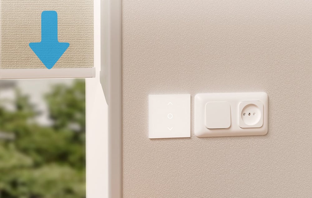 White smart blind switch on the wall next to a window with a closing blind