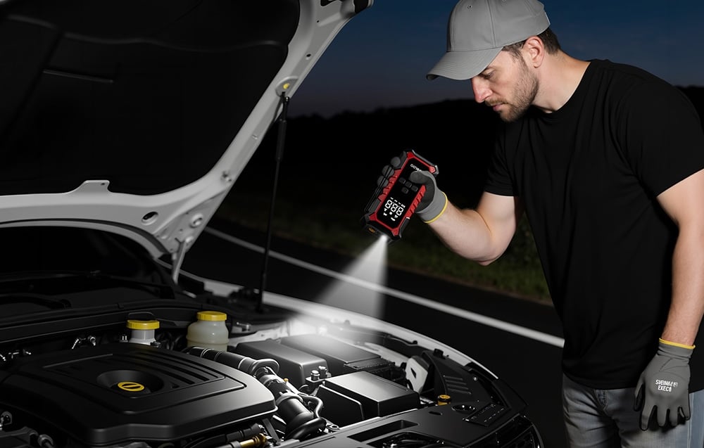 A man illuminates a car’s engine compartment with a portable device featuring a built-in flashlight