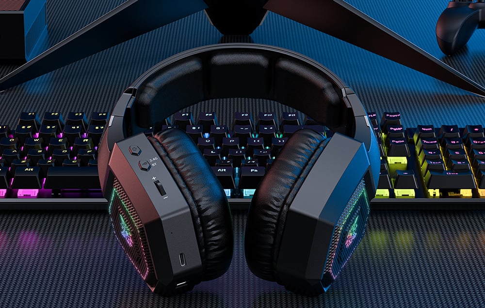 Black Onikuma gaming headphones lying on an illuminated keyboard