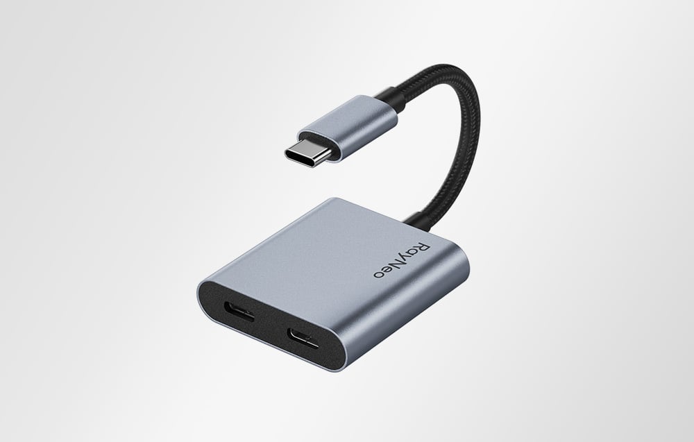 RayNeo USB-C adapter with two ports, shown against a light background in a slight close-up.