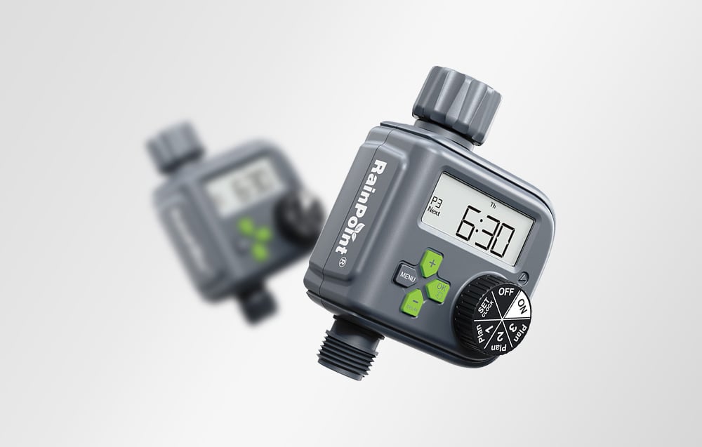 Two graphite RainPoint® irrigation controllers on a gray background, one in sharp focus in the foreground, the other blurred in the background