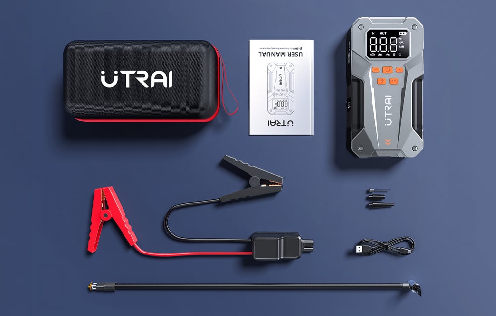 A car starter and a set of accessories, including a case, instruction manual, cables with clamps, and connectors.