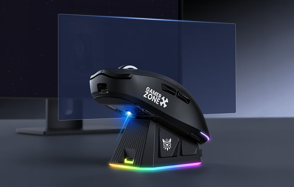 Gaming mouse with charging dock on a black desk, monitor in the background