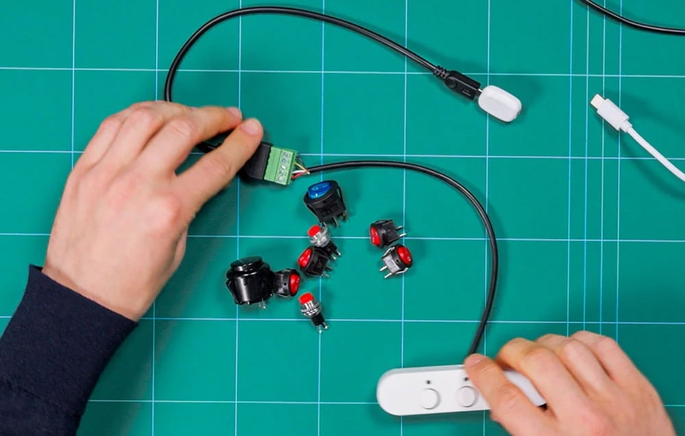 5-pin Shelly terminal block held in hands and connected to wires on a green background