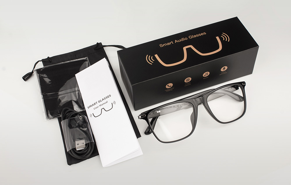 A set containing black glasses, a case, a charging cable, a user manual, and an elegant box.