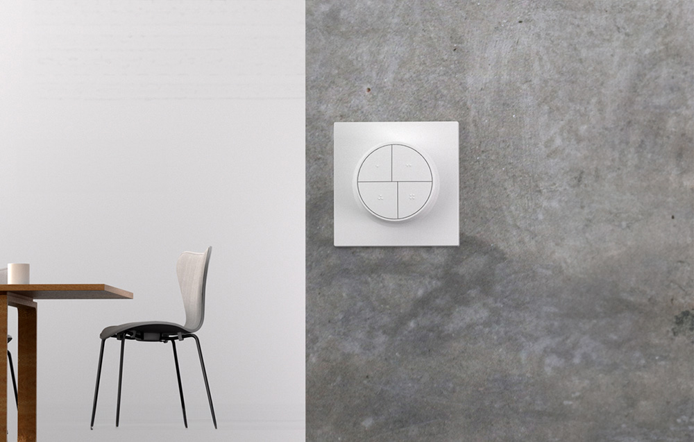 Smart button on the gray wall, table and chair on the left