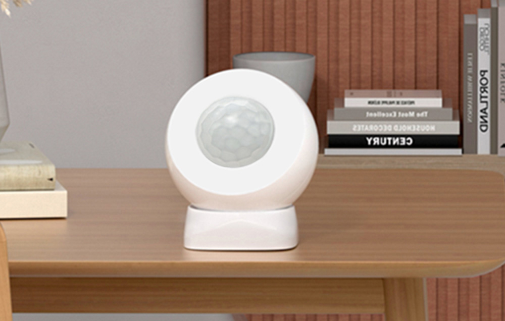 Motion sensor set on a desk in a home interior next to books and decorations