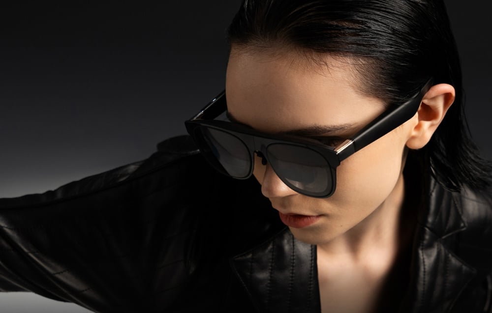 Black-haired woman wearing a black jacket and AR (Augmented Reality, augmented reality) glasses