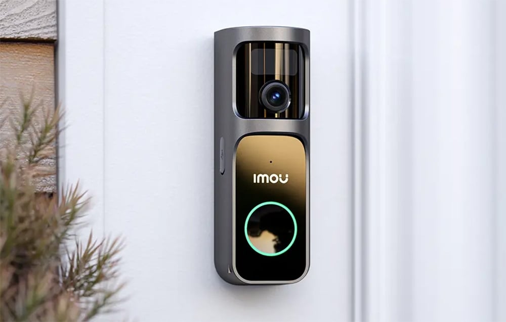 A silver-and-black Imou video intercom with a lens and a green-backlit button against a white wall