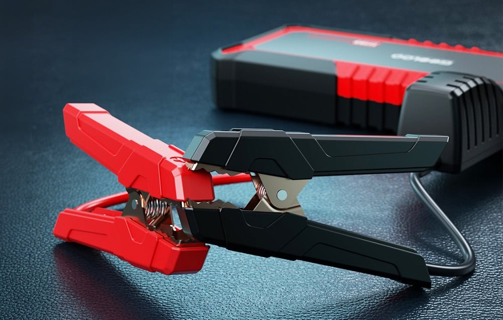 Close-up of the red and black clamps connected to the car jump starter