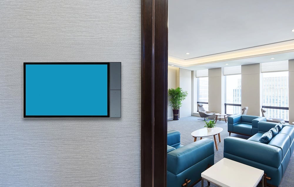 Touch panel with blue screen mounted on the wall in the living room with blue chairs