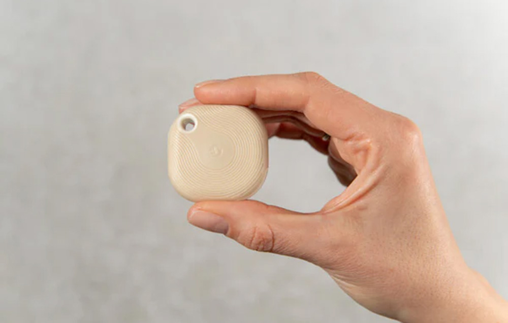Scene activation button held in the hand on a gray background