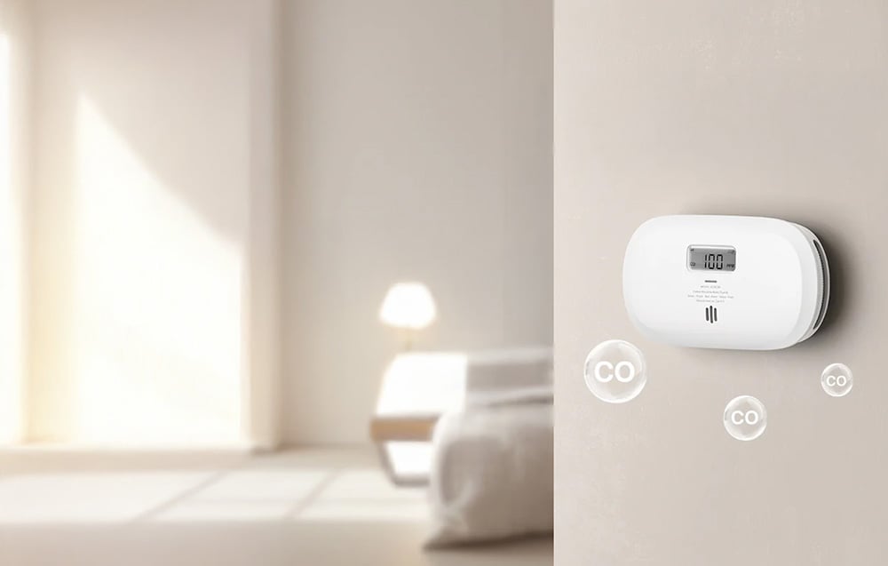 Carbon monoxide detector mounted on a wall in a bright room with CO icons floating prominently.
