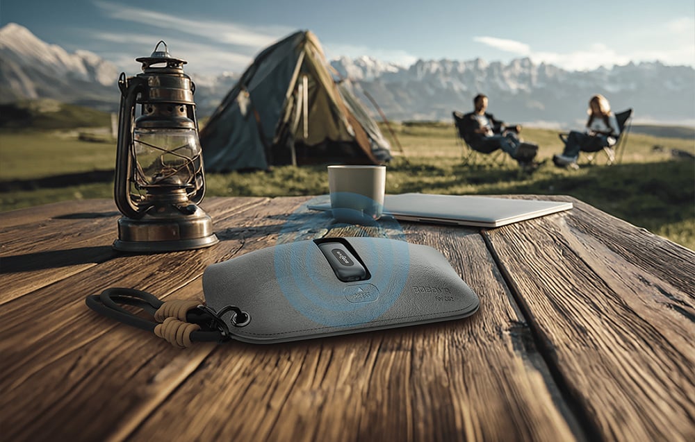 The BOBOVR CG2 protective case with charging function placed on a wooden table during an outdoor camping trip.