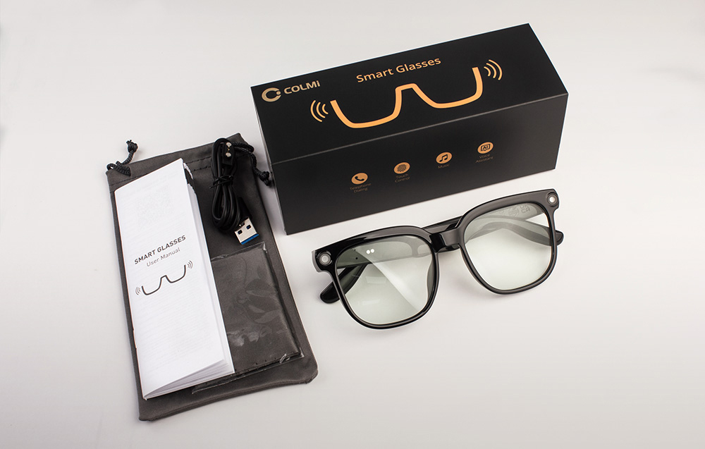 Two men wearing glasses talking at a table, with a sound wave icon visible between them.