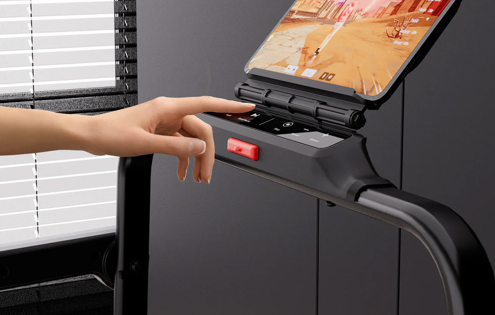 Hand reaching for a button on the treadmill console with a tablet mounted on it