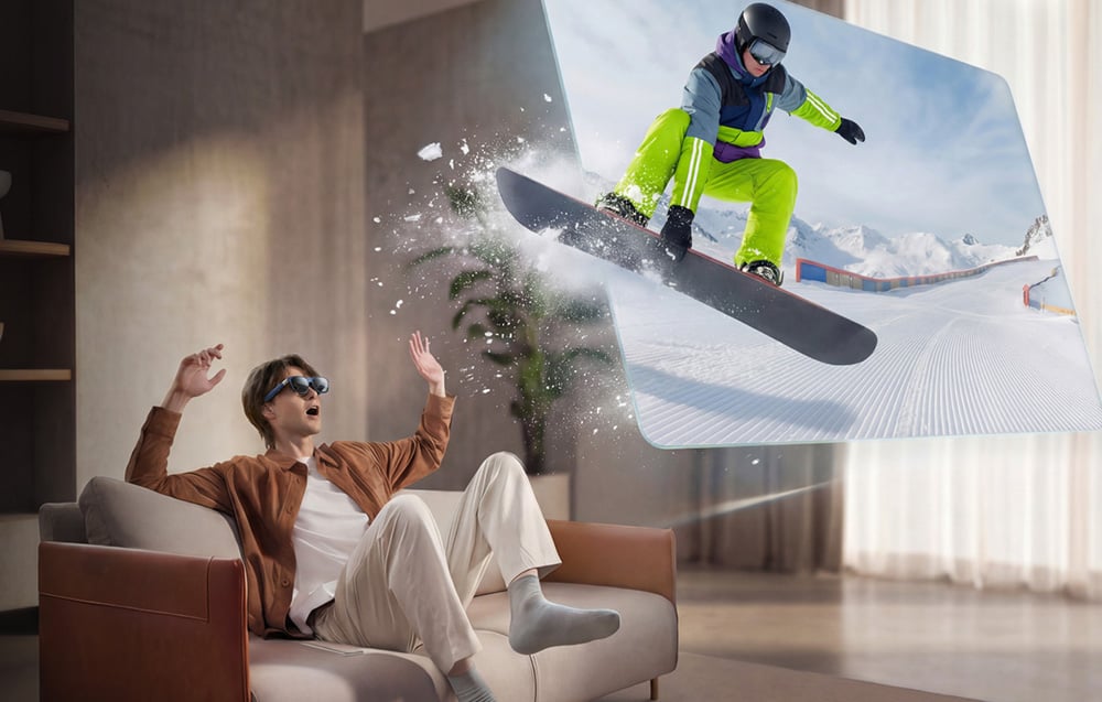 A man wearing AR glasses sits on a couch; on the right, an image of a person on a snowboard is displayed