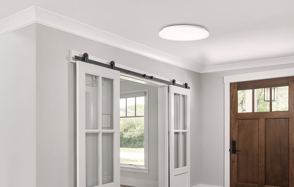 Yeelight MercuryE C260 lamp mounted in a bright hallway with sliding doors and a wooden front door.