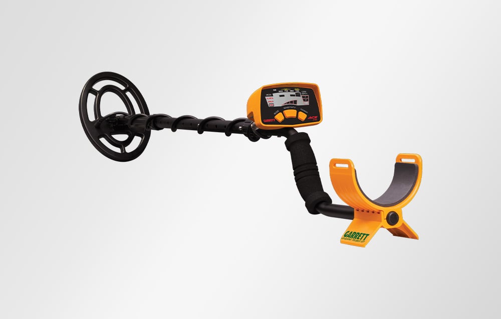 Garrett ACE 150 metal detector visible from the side against a bright background.