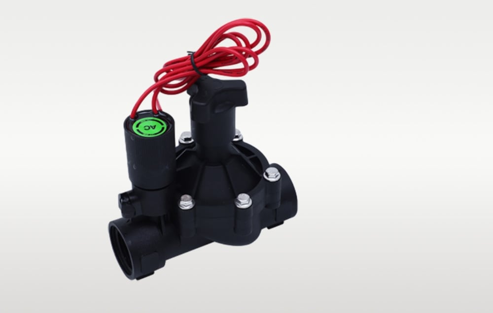 Small black irrigation solenoid valve with red wire shown at an angle from above