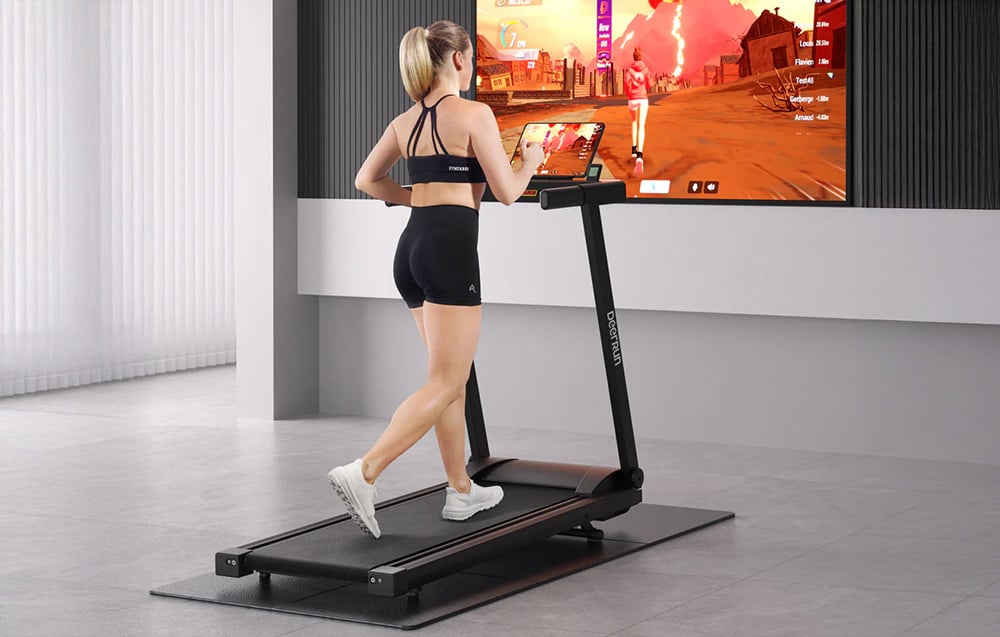 A woman exercises on a treadmill in a modern interior, looking at a screen with a fitness game