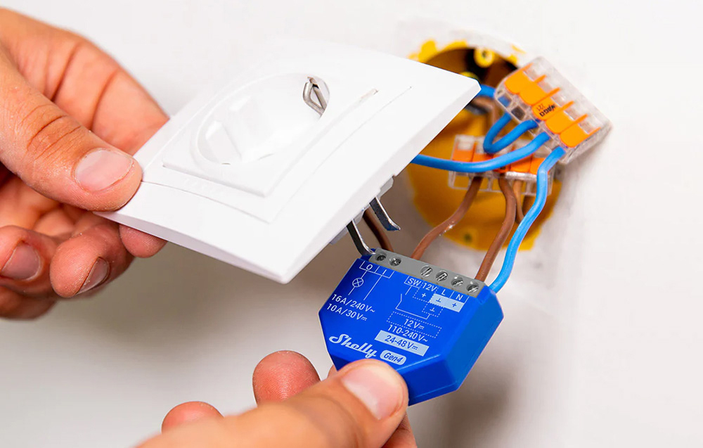 Connecting wires from the controller to a white electrical outlet before mounting it in the wall.
