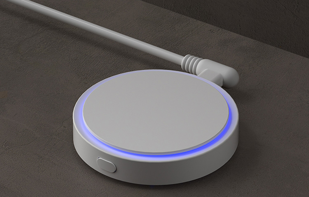 White sensor with blue LED backlight, wired and placed on a dark surface