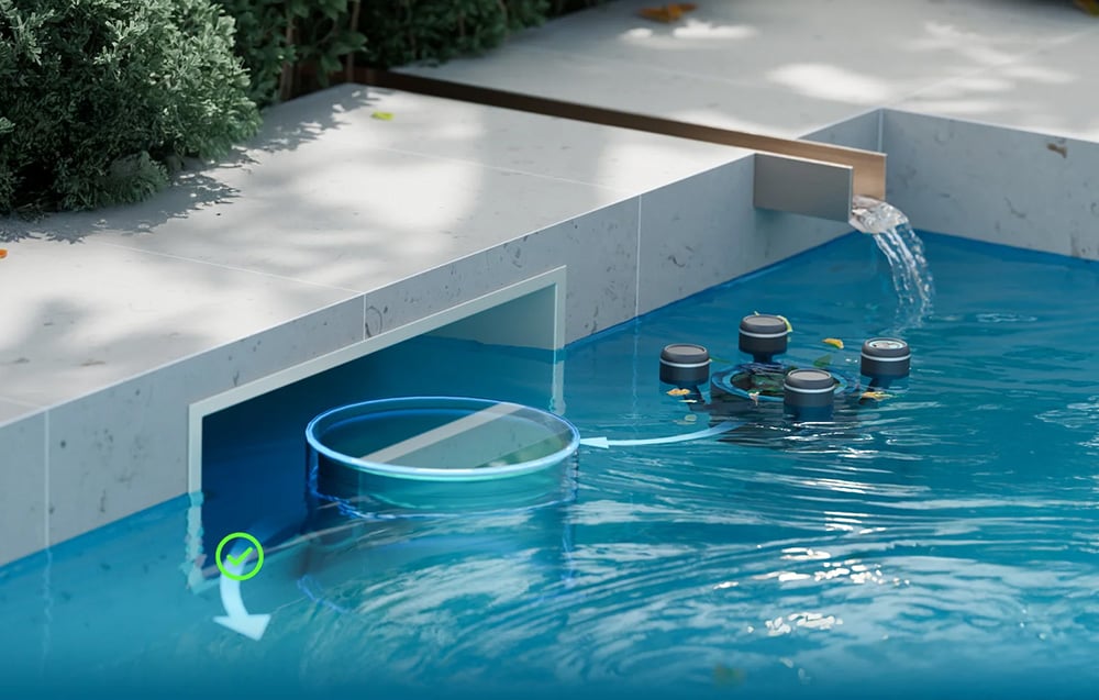 The swimming robot draws water from the pool through a wall-mounted skimmer niche connected by a white hose to the filtration system