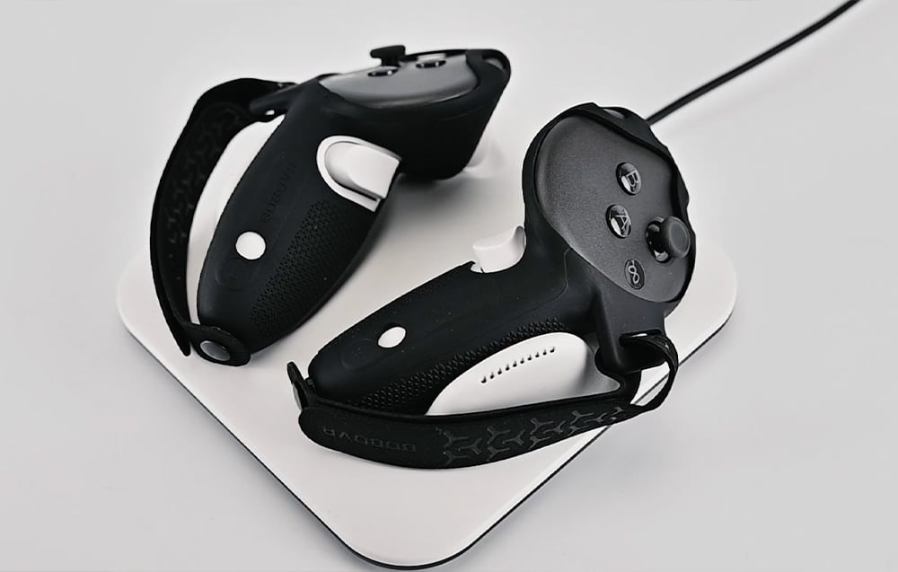 Two black and white VR controllers placed on the white BoboVR CD3 charging station