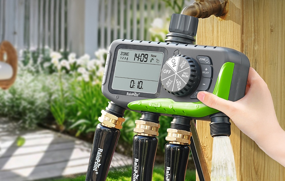 RainPoint 4-zone irrigation controller connected to an outdoor faucet, with 4 hoses connected at the bottom, a hand clicking the button
