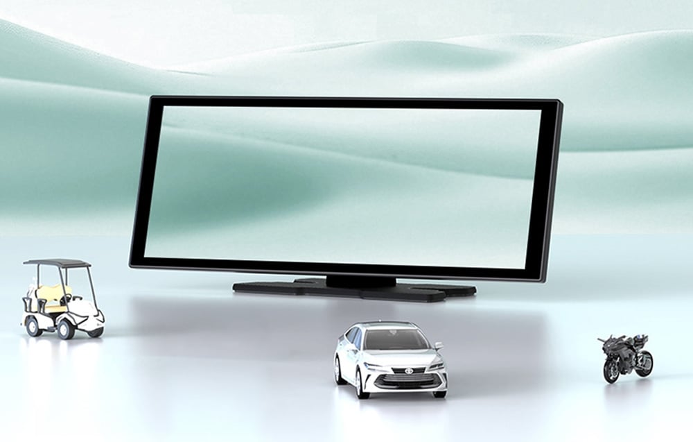Large screen on a bright background next to small models of a white car, motorcycle, and golf cart