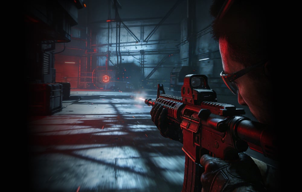 First-person view of a gamer aiming an assault rifle in a dim, industrial corridor with red lighting