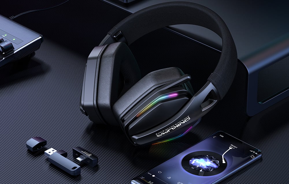 Onikuma headphones lying next to the adapter and smartphone