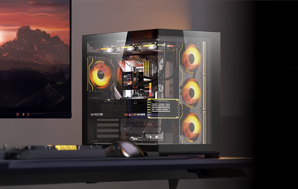 Computer case with orange RGB fans next to a monitor on a dark gaming desk