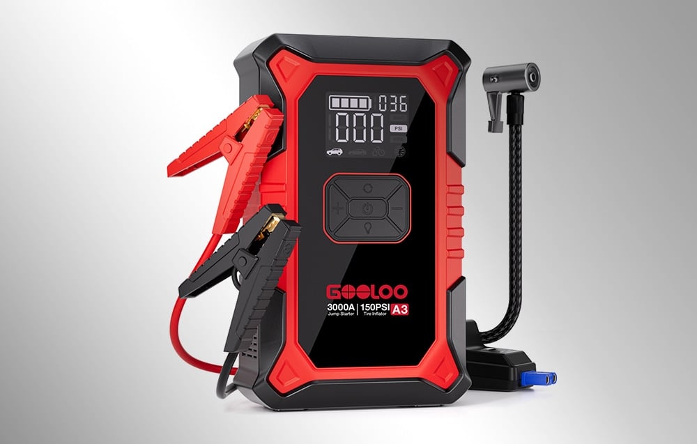 Red and black Gooloo A3 jump starter with clamps and hose on a gray background