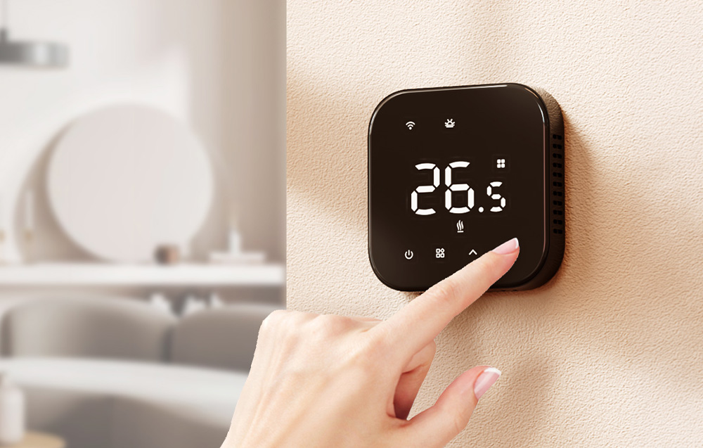 A hand pressing a button on the thermostat