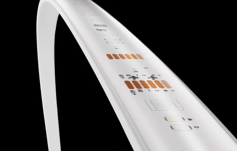 A close-up of a flexible white lighting strip with visible mounting points against a black background.