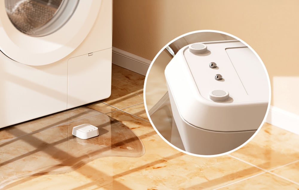MEROSS smart water leak sensor lying in a puddle of water next to the washing machine