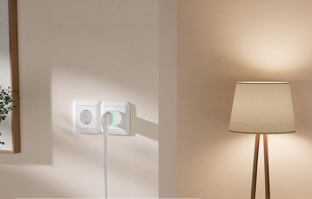 smart socket on a beige wall next to a lamp with a brown shade