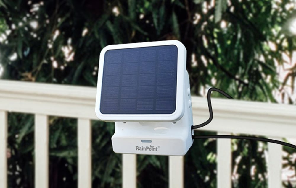 White RainPoint solar panel mounted on outdoor railing with visible black wire