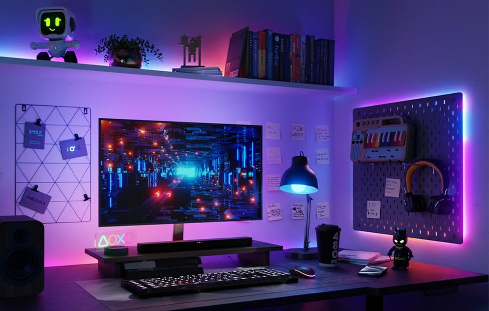A gaming setup lit by pink and blue LED strips