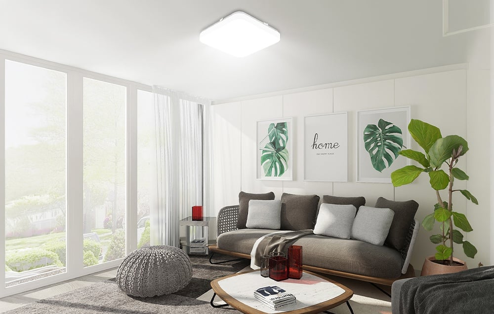 Living room with gray furniture and large windows, featuring a flat, square ceiling light